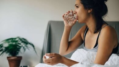 Pregnant woman holding a glass of water and a plate of ginger, symbolizing natural remedies for managing morning sickness.