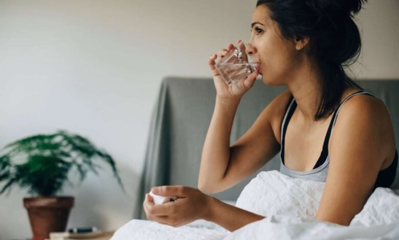 Pregnant woman holding a glass of water and a plate of ginger, symbolizing natural remedies for managing morning sickness.