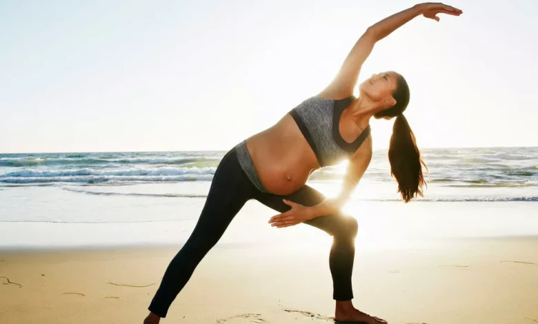 Pregnant woman practicing yoga outdoors